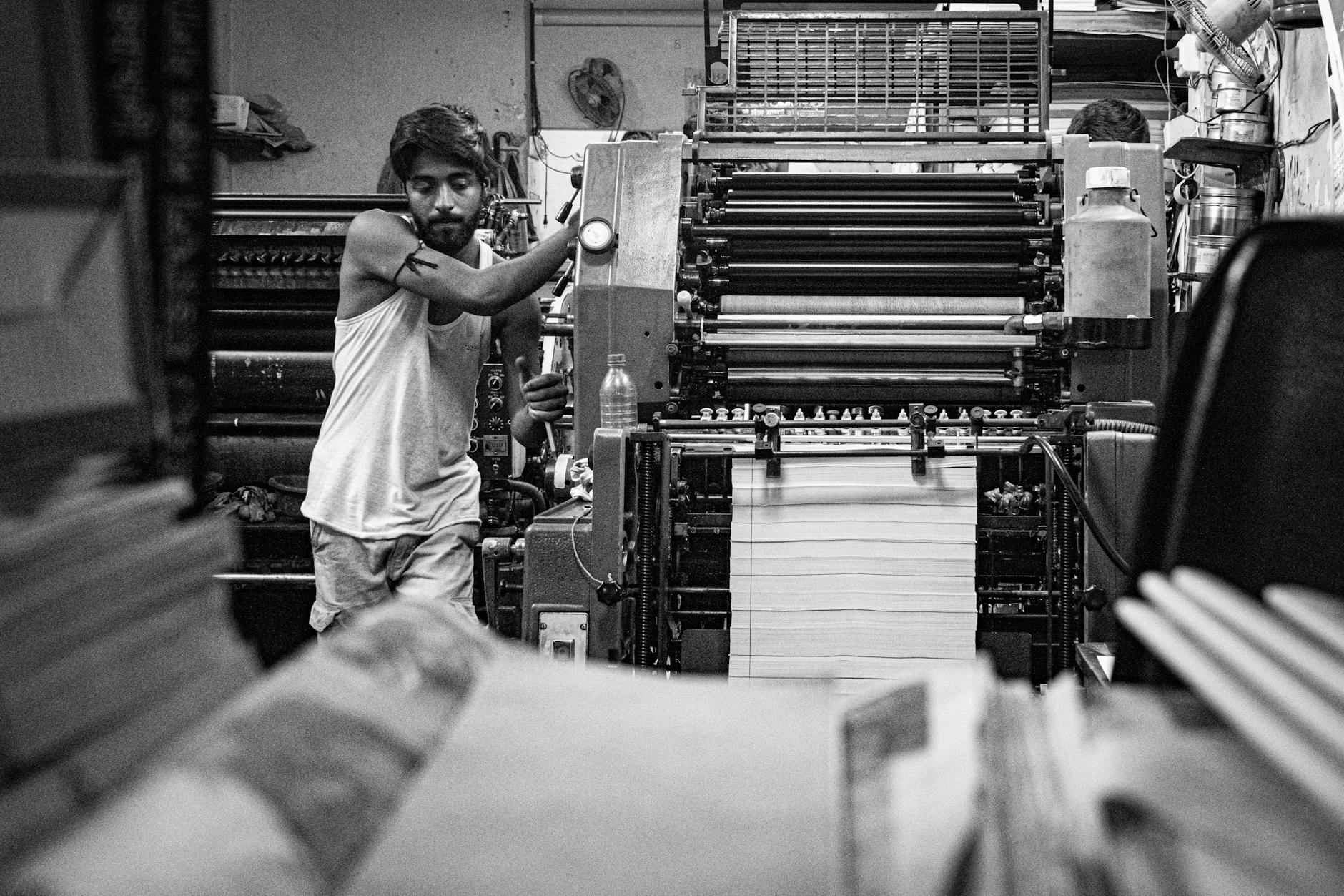 monochrome print shop with worker operating machine